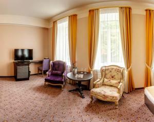 a hotel room with a bed and a table and chairs at Hyde Park Hotel in Tver