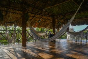 a resort with hammocks in a straw roof at L' Europe in Puerto Limón