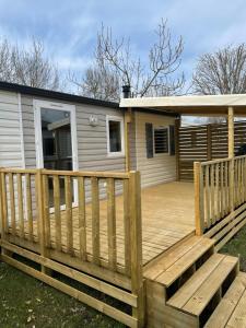 a wooden deck with a house at Mobilhome 6 personnes in Saint-Georges-de-Didonne