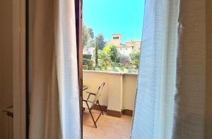 - une vue depuis la fenêtre d'un balcon avec une chaise dans l'établissement Flavel Colosseo, à Rome