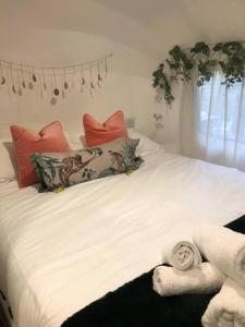een wit bed met kussens en handdoeken erop bij Airstream Woodland Escape in Galston