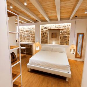 um quarto com uma cama num quarto com uma parede de pedra em In centro da Viola - Eco Design Rooms em Olbia