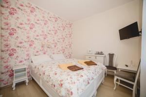 a bedroom with a bed with a floral wallpaper at Willa Ludwik SPA & Wellness in Dębki