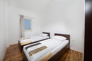 dwa łóżka w pokoju z oknem w obiekcie Apartmani Residence Jana w mieście Vabriga