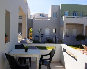 a small balcony with a table and chairs on a building at Golden Sun Boutique in Malia