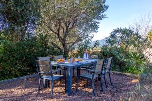 a blue table with chairs and fruit on it at Le moulin de Figari, nouvelle climatisation in Figari +35 photos