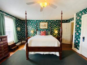 a bedroom with a bed with green floral wallpaper at Terrell House B&B in Burnsville