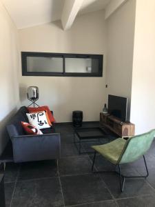 a living room with a couch and a television at Charmante maison aux portes des Cévennes in Alès
