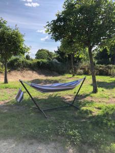 a hammock sitting in the grass in a field at Charmante maison aux portes des Cévennes in Alès