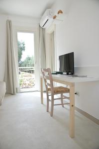 een bureau met een televisie en een stoel in een kamer bij TerreAmare Agriturismo in Porto Cesareo