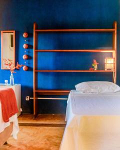 Dormitorio azul con cama y pared azul en Pousada Guaiamum, en Itacaré
