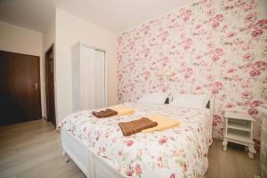 a bedroom with a bed with pink floral wallpaper at Willa Ludwik SPA & Wellness in Dębki