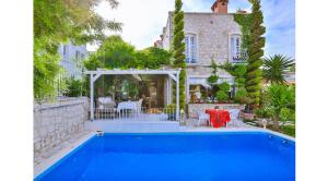 a house with a swimming pool in front of a house at Stone Villa,Large Garden,Swimming Pool, Very Close the Beautiful Beach . in Cesme