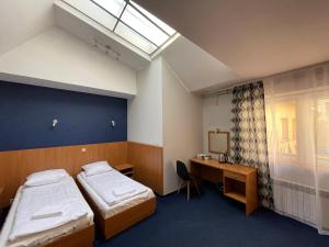 a room with two beds and a desk and a window at Garbarska 22 Aparthotel in Krakow