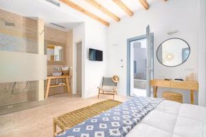 1 dormitorio con cama, escritorio y espejo en IL Vento Premium, en Mykonos ciudad