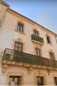 a building with a balcony on the side of it at Studio mirabeau les halles 15m2 climatisation in Narbonne +1 photo
