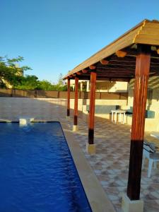 a swimming pool with a wooden pavilion and a swimming poolvisor at قرية رمسيس الكيلو45 الساحل الشمالي in Borg El Arab