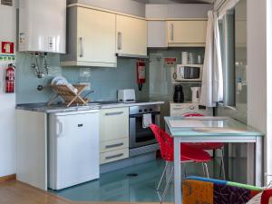 a kitchen with white cabinets and a table at Anthero Quental Boutique Apartment in Ponta Delgada