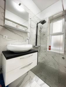 a white bathroom with a sink and a shower at Luxury Apartment ASIA 2 Rijeka in Rijeka