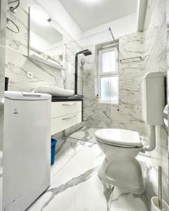 a white bathroom with a toilet and a sink at Luxury Apartment ASIA 2 Rijeka in Rijeka