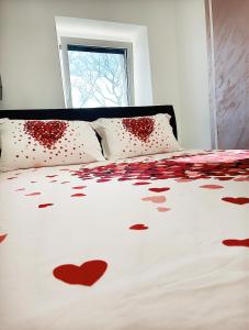 a bed with red hearts on the sheets at Luxury Apartment ASIA 2 Rijeka in Rijeka