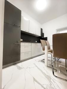 a kitchen with white cabinets and a table and chairs at Luxury Apartment ASIA 2 Rijeka in Rijeka
