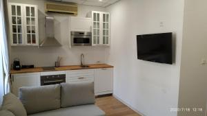 a kitchen with white cabinets and a couch in a room at Studio Neuf Climatisé tout équipé #3 in Toulon +4 photos