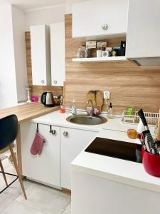 cocina blanca con fregadero y encimera en Felicity Super Central Apartment, en Burgas