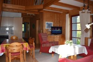 cocina y sala de estar con mesa y sillas en Ferienhaus Nr 3A2, Feriendorf Hagbügerl, Bayr Wald, en Waldmünchen