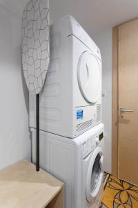 eine Waschmaschine mit einer Mikrowelle darüber in der Unterkunft MICRO in Gżira