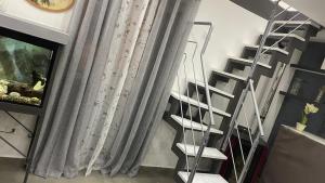 uma escada em espiral branca num quarto com lareira em La Maison2 em Mondragone