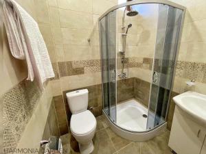a bathroom with a shower and a toilet and a sink at Harmonia Garden Hotel&Gastroyard in Garni