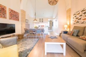 sala de estar con sofá y mesa en Cream Loft. Siente Jerez. Parking+Wifi+Netflix, en Jerez de la Frontera