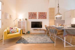 - un salon avec une table à manger et une télévision dans l'établissement Cream Loft Siente Jerez Parking Incluido, à Jerez de la Frontera