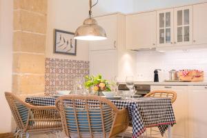 uma cozinha com uma mesa com cadeiras e uma sala de jantar em Cream Loft. Siente Jerez. Parking+Wifi+Netflix em Jerez de la Frontera