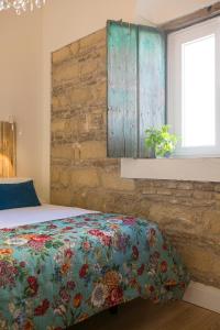 a bedroom with a bed and a brick wall at Cream Loft. Siente Jerez. Parking+Wifi+Netflix in Jerez de la Frontera