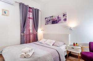 - une chambre avec un lit et des serviettes dans l'établissement Apartman Nicoletta, à Split