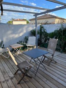 2 chaises et une table sur une terrasse en bois dans l'établissement Studio indépendant très calme, à Saint-Jean-de-Védas
