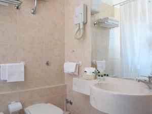 W łazience znajduje się umywalka, toaleta i lustro. w obiekcie B&B La Casa Di Rosy w Rzymie