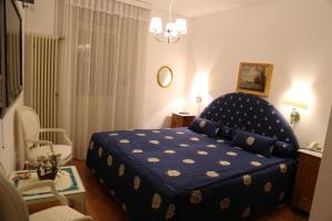 Schlafzimmer mit einem Bett mit blauer Decke in der Unterkunft Hotel Corona in Locarno