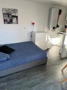 een slaapkamer met een bed in een witte kamer bij Studio indépendant très calme in Saint-Jean-de-Védas