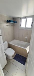 y baño con aseo, bañera y lavamanos. en Lovely 1betroom apartment near the beach, en Pyla