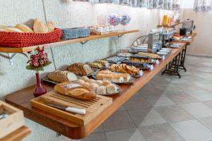 a long table filled with lots of bread and pastries at Bella Casa Flat Service in Bertioga