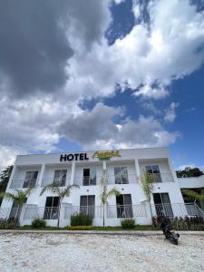 un hotel con palmeras frente a un edificio en Hotel Monte Bello en Doradal