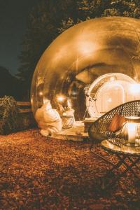 kula siedząca na ziemi obok krzesła w obiekcie Bubble-Tent Elzach inklusive Hot Tube Badefass w mieście Elzach