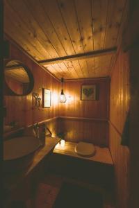 a wooden bathroom with a sink and a toilet at Bubble-Tent Elzach inklusive Hot Tube Badefass in Elzach