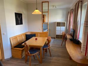 una sala da pranzo con tavolo e sedie in legno di Landhaus Sonnenbichl a Oy-Mittelberg