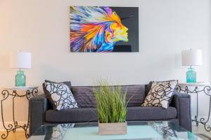 a living room with a couch and a painting of a lion at Flip Flop Paradise in Hollywood Florida in Hollywood