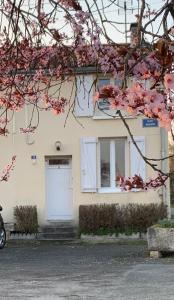 uma casa branca com uma porta branca e janelas em La maison d’Eloi em Montignac-Charente