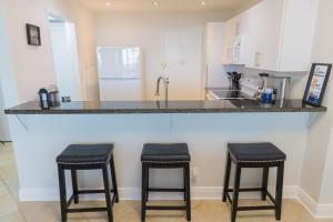 a kitchen with a counter with two stools at it at Flip Flop Paradise in Hollywood Florida in Hollywood